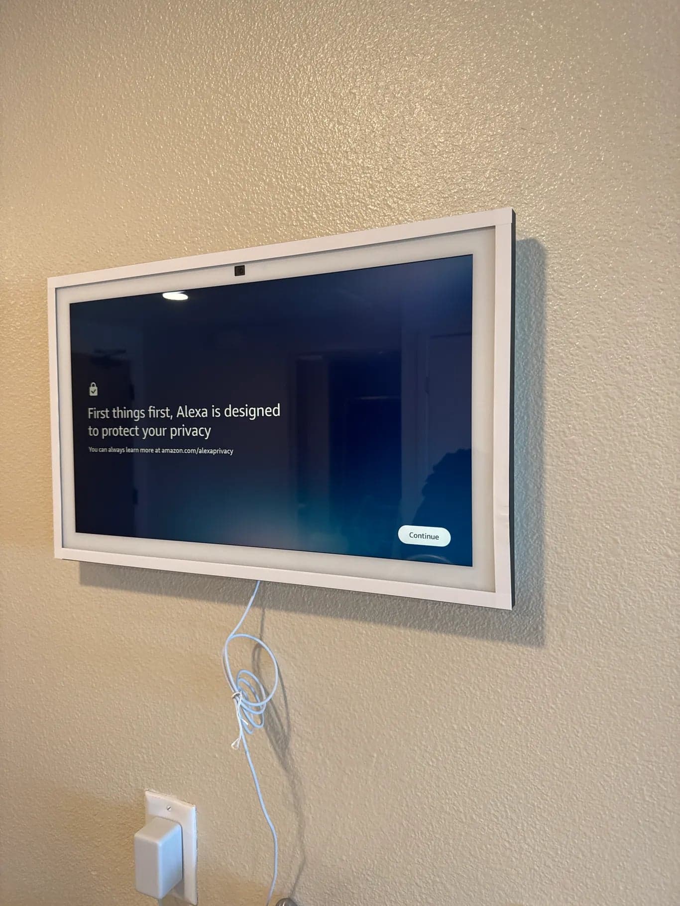 A smart display mounted on a bedroom wall