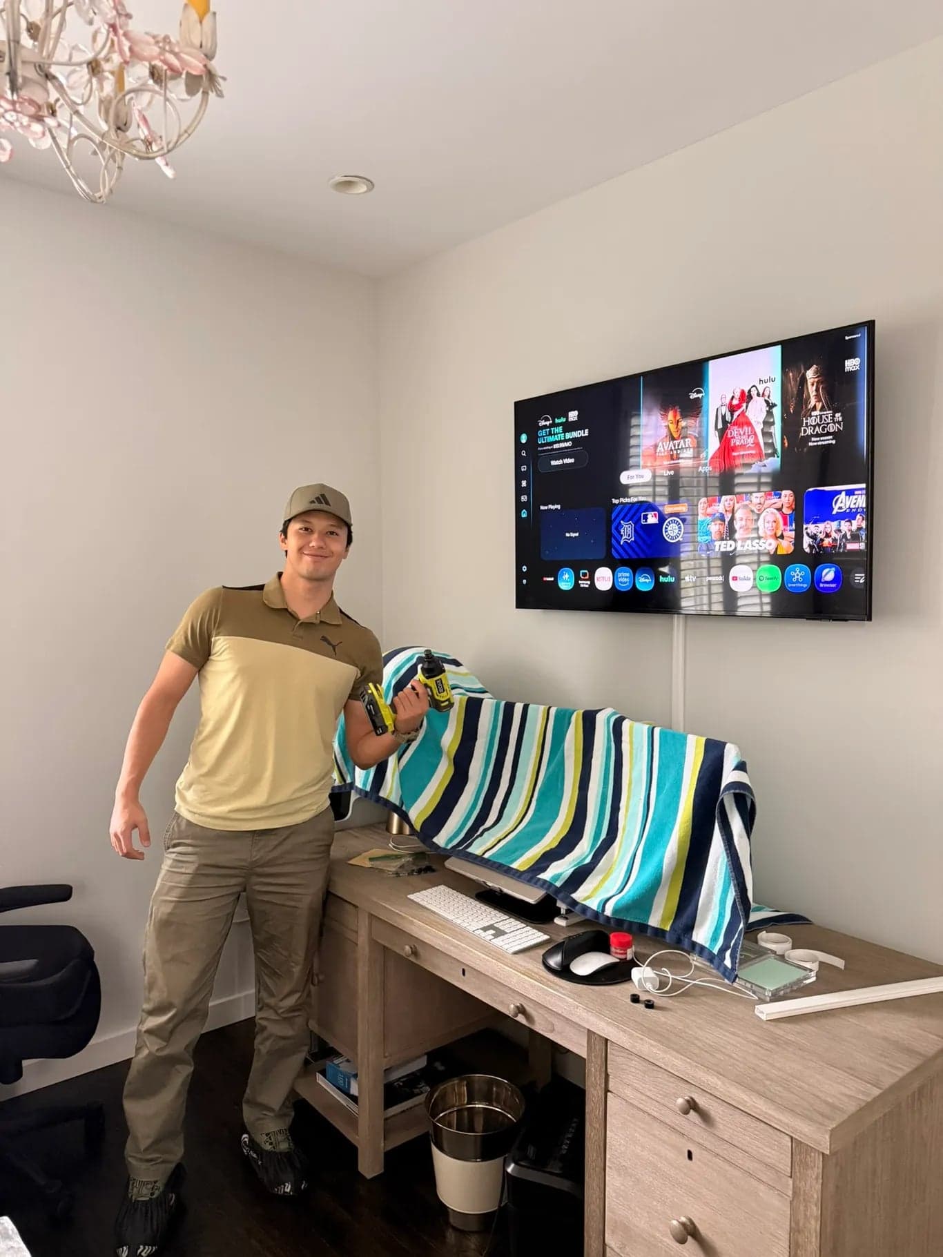 A flat screen TV mounted on the wall above a home office desk