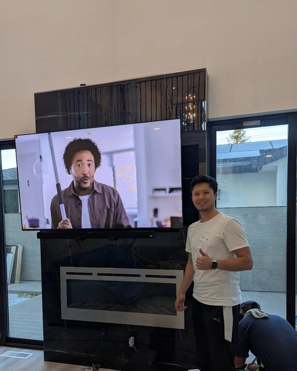A flat screen TV mounted on a tough tile mantel wall, with a soundbar installed below